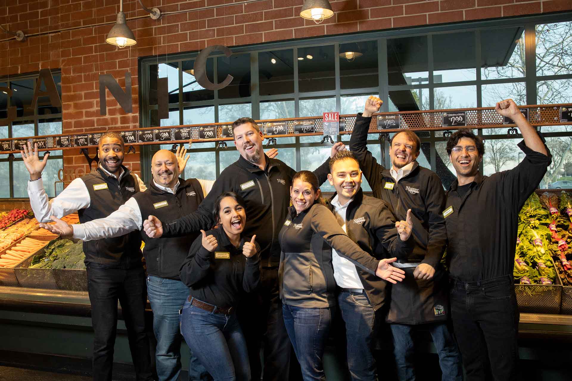 Nugget Markets associates cheering in front of produce