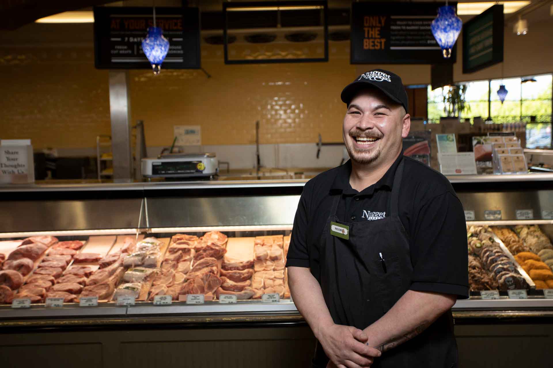 Meat Department associate in front of the meat counter