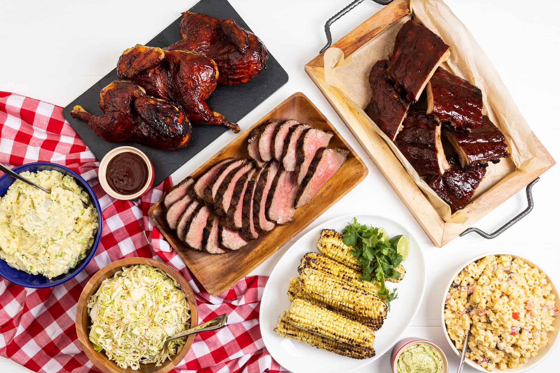 Memorial Day meals with BBQ chicken, baby back ribs, tri-tip, corn on the cob, and macaroni salad