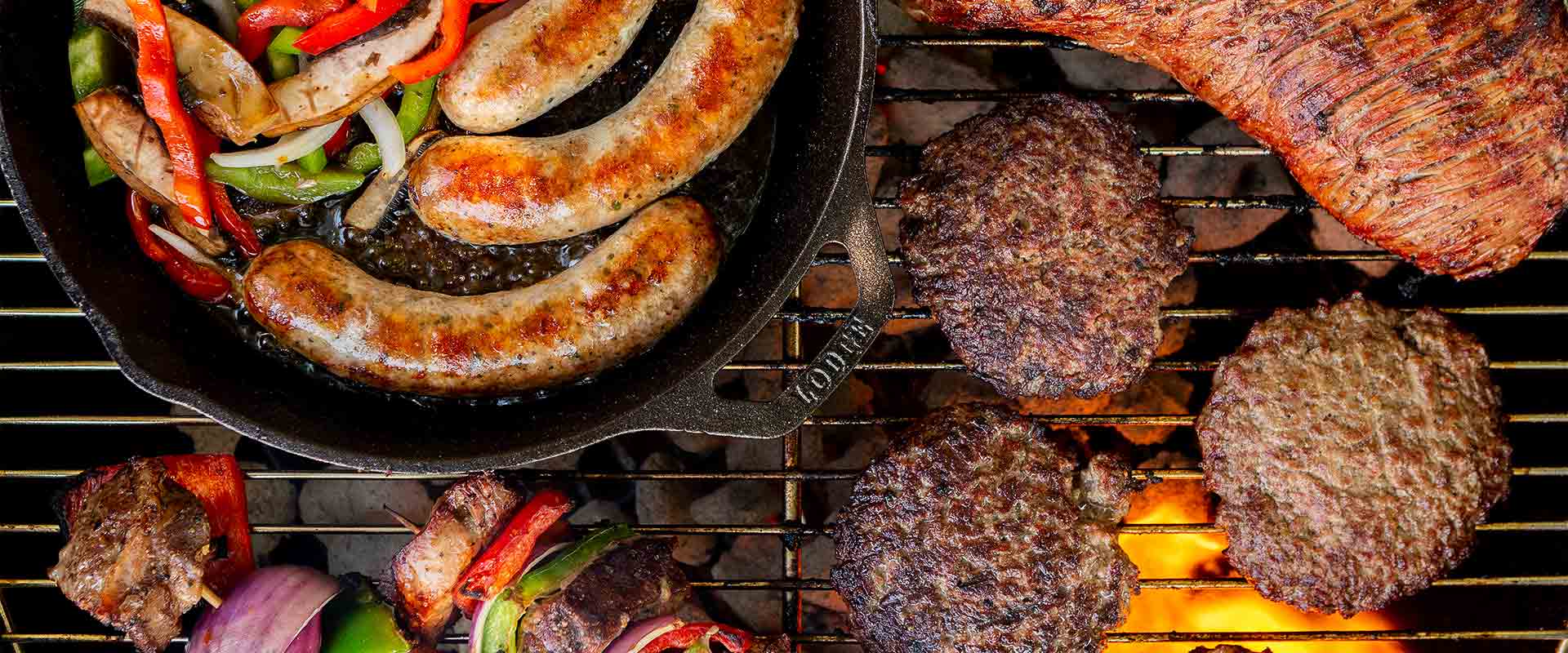 Sausages, hamburgers, and kabobs on a grill